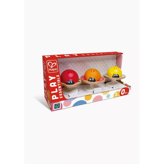 Best toy shop in Qatar – baby playing with Hape Stay-Put Baby Rattles on a smooth surface, perfect for travel and sensory development, available from the best online toy shop in Qatar with toy delivery service in Qatar