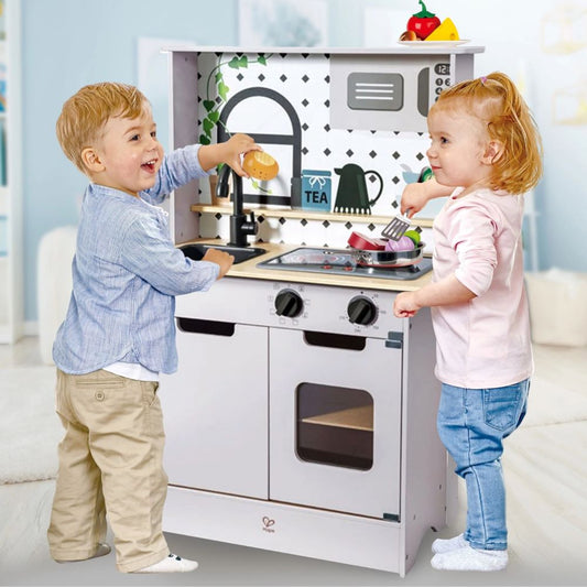 Best toy shop in Qatar ,kids playing with the Hape Light & Sound Kitchen Playset, learning through imaginative role-play, available to buy kids toys online in Qatar from the best online toy shop with toy delivery service