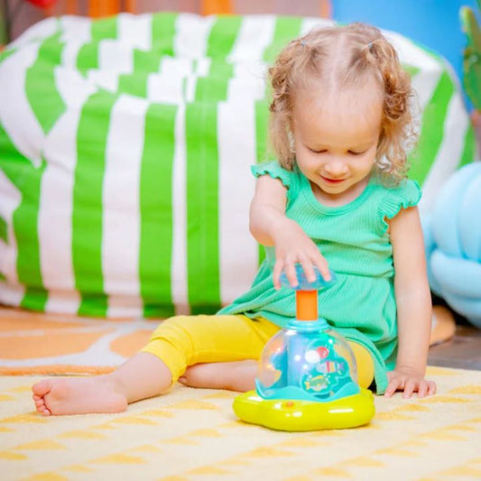 Kids playing with Bright Starts Press & Glow Spinner – fun activity toy to buy kids toys online in Qatar from the best online toy shop in Qatar