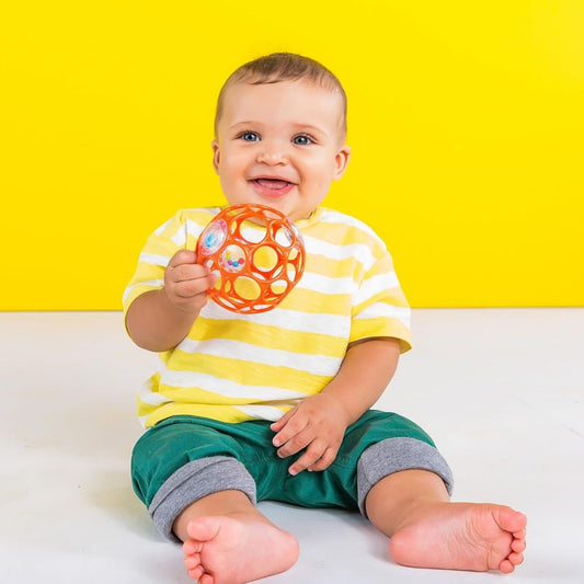 Baby playing with Bright Starts Oball Easy-Grasp Rattle Orange – fun developmental toy – buy kids toys online in Qatar with fast toy delivery service