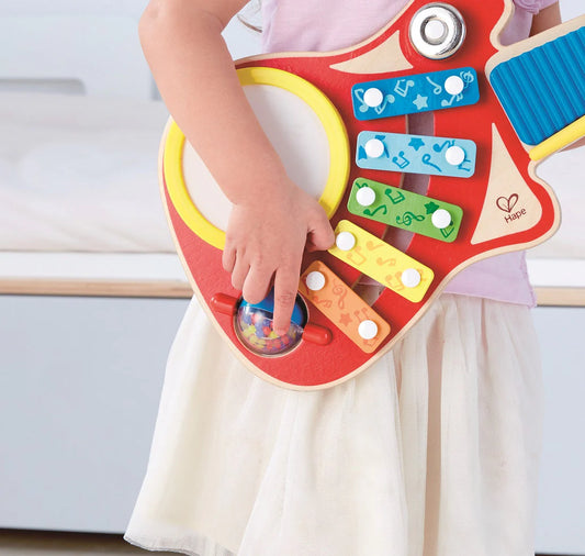 Best toy shop in Qatar – toddler playing with Hape 6-in-1 Music Maker, exploring musical sounds and instruments, available from the best online toy shop in Qatar with toy delivery service in Qatar