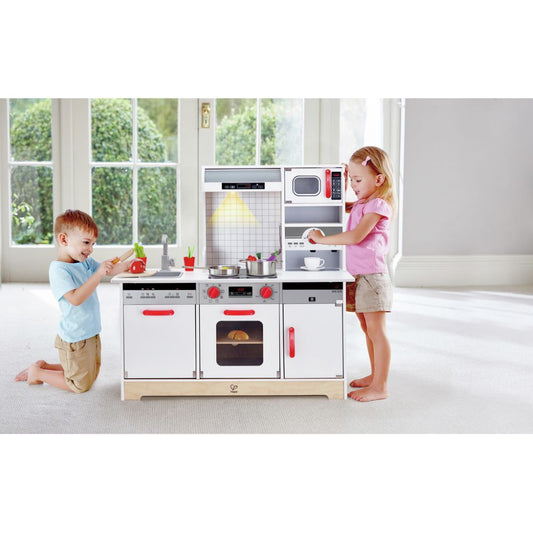 kids playing with Hape All In 1 Kitchen using pretend stove, fridge, and sink, available to buy kids toys online in Qatar from the best online toy shop with toy delivery service in Qatar