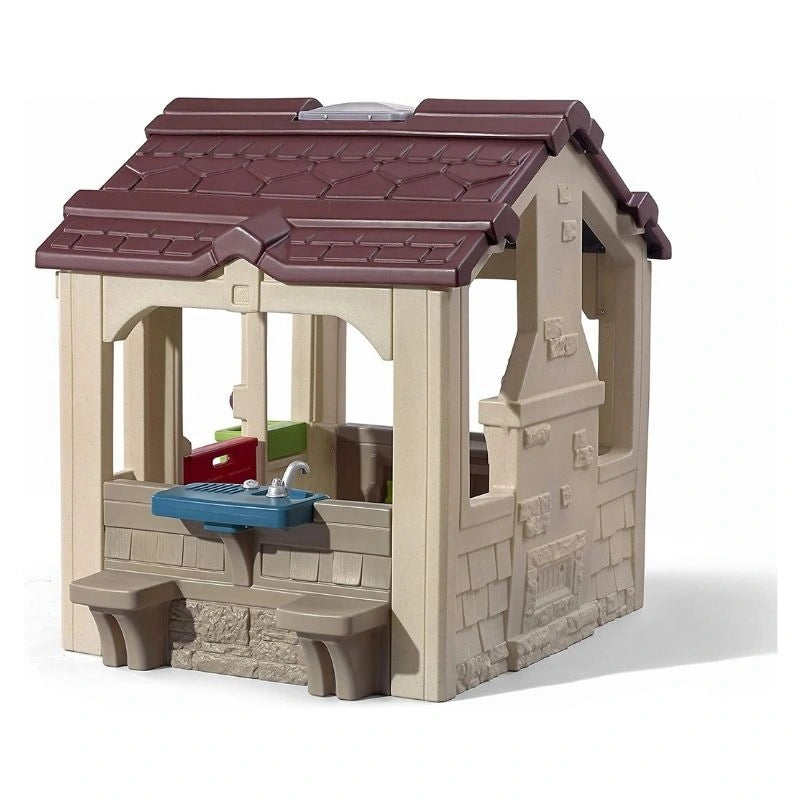 kids outdoor playhouse Qatar -A beige and brown plastic playhouse designed to look like a charming cottage with a kitchen and sink area, suitable for children's play.